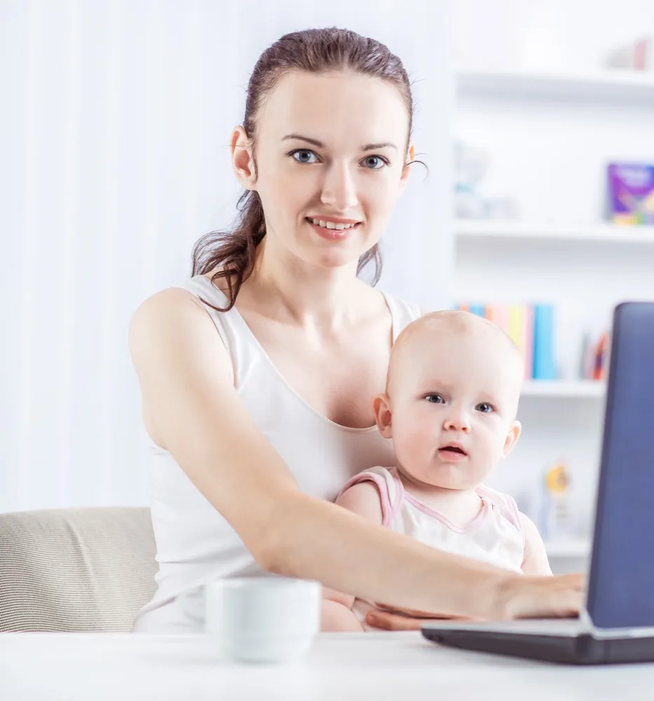 A mother smiling with her baby during a virtual consultation